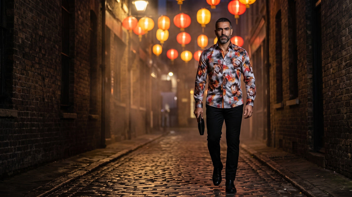 Dragon print shirt men: Middle Eastern man late 30s, grey-flecked beard, mid-stride toward camera in a lantern-lit alley at night, low angle, Claudio Lugli Dragon Fire shirt buttoned to the collar, black trousers and boots
