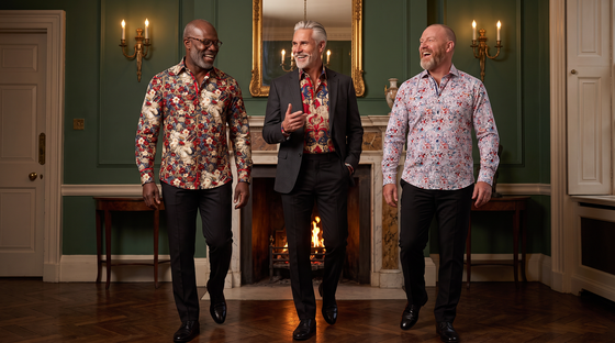 Halloween party outfit for men over 40: three men in a Georgian drawing room - Nigerian-British 52 glasses in Heritage Tapestry, Greek-Cypriot 58 silver hair in Royal Guardian, Scottish 47 shaved head in Wild Bloom