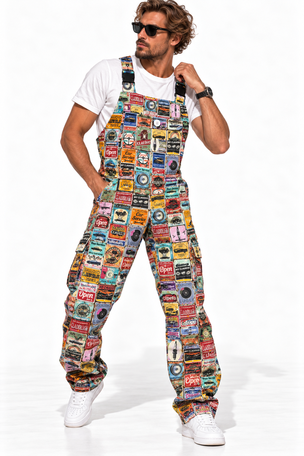 Claudio Lugli Retro Car Service Overalls on a model, front view showing a multicolour vintage motoring-sign collage, bib pocket and loose legs with white trainers