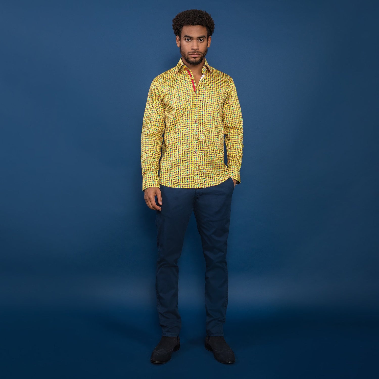 Man wearing Claudio Lugli Houndstooth Multicolour Printed Shirt with blue pants against a blue background