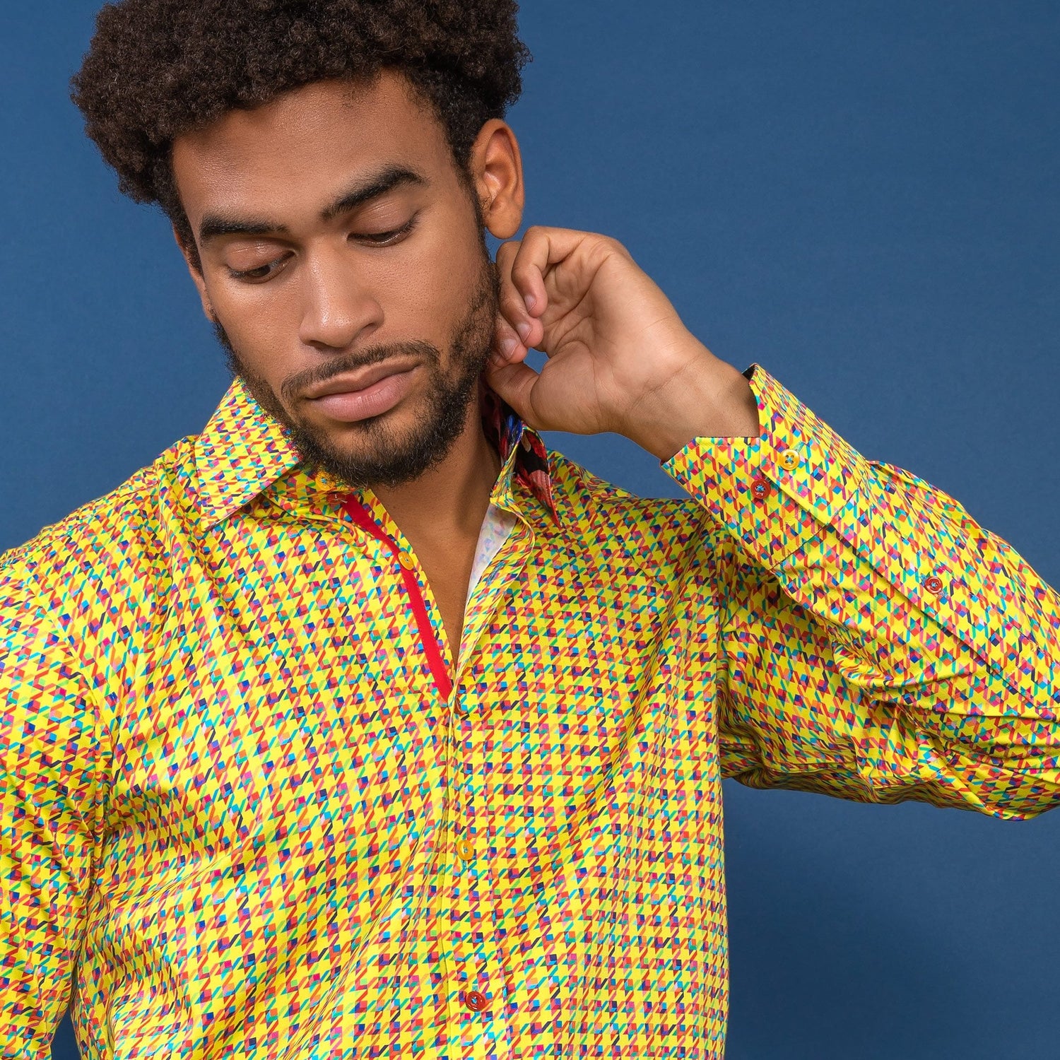 Man wearing vibrant houndstooth multicolour printed shirt by Claudio Lugli against blue background