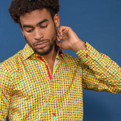 Man wearing vibrant houndstooth multicolour printed shirt by Claudio Lugli against blue background