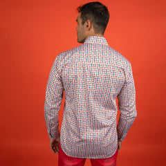 Man wearing Houndstooth Multicolour Printed Shirt with vibrant colors and a sleek, contemporary design in front of a red backdrop.