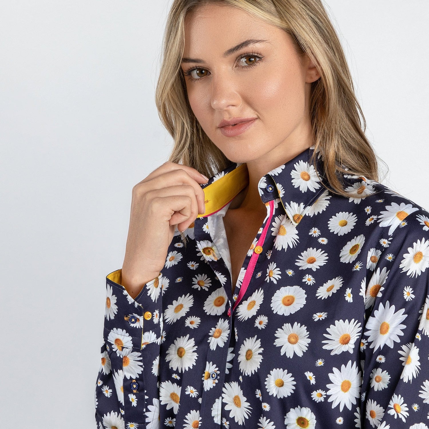 Woman wearing navy daisy flower print shirt with yellow and pink accents, showcasing luxurious satin and cotton blend fabric.