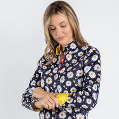 Woman wearing navy daisy flower print women's shirt with folded yellow cuffs.