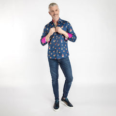 Man wearing THE CROWN Regal Print Shirt by Claudio Lugli with crown motifs, fuchsia inserts, vibrant buttons, and aqua placket strip.