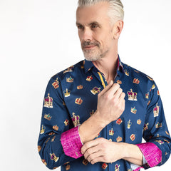 Man wearing THE CROWN Regal Print Shirt by Claudio Lugli with colorful crown motifs and bold fuchsia inserts, showcasing sophistication and confidence.