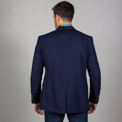 Back view of a man wearing a navy Signature fitted jacket with multicolour stitching, showing colourful collar and paired with jeans.