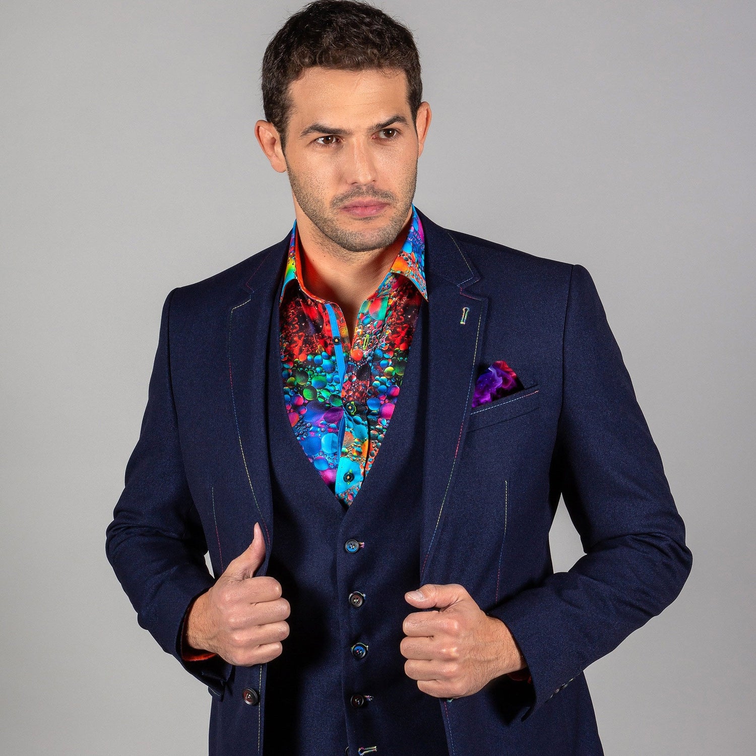 Man wearing a navy Signature Fitted Jacket with multicolour stitching and an arty splash impression.