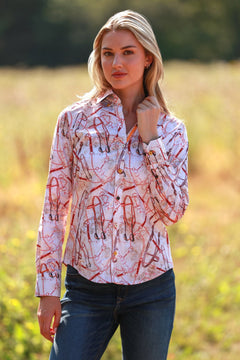 Woman wearing Snaffle Women Print Shirt, standing in a sunny countryside, showcasing equestrian-themed design and luxurious satin-cotton blend.