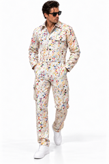 Claudio Lugli Paint Splattered Jumpsuit on a model, front view showing multicolour splashes on a cream ground, long sleeves and pockets with white trainers