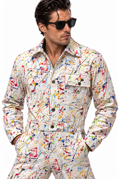 Claudio Lugli Paint Splattered Jumpsuit close-up on a model, showing red, blue and yellow splashes on cream, pointed collar, dark buttons and flap chest pockets