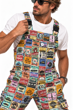 Claudio Lugli Retro Car Service Overalls close-up on a model, showing vintage garage signs, car-service motifs, bib pocket and shoulder strap buckles over a white T-shirt