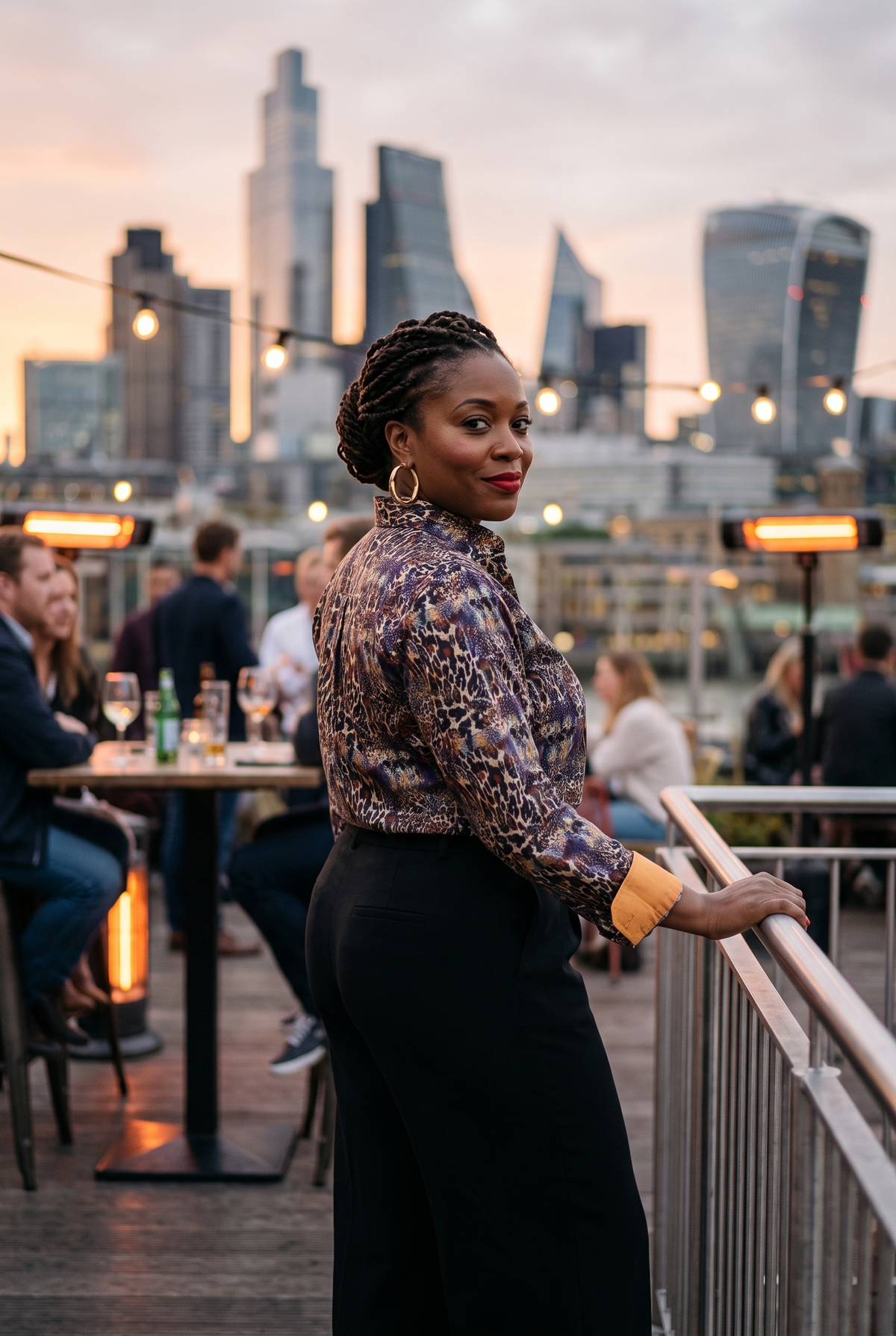 A woman in her early forties wearing the Claudio Lugli Catwoman Leopard Womens Print Shirt on a City of London rooftop bar at dusk, turned away with a hand on the rail and looking back into the lens, the dark ornate animal print and warm tan contrast cuffs clearly visible